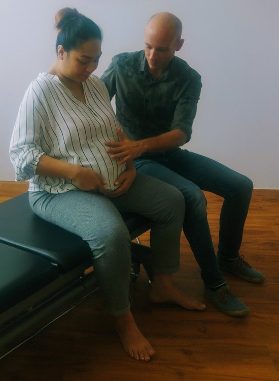 Arnaud Le Coz ostéopathe traite une femme enceinte lors d'une consultation d'ostéopathie..